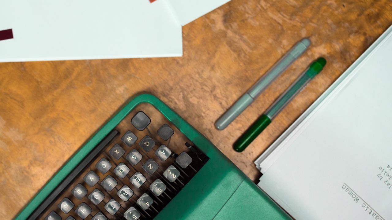 Calculadora y lápices sobre un escritorio de madera