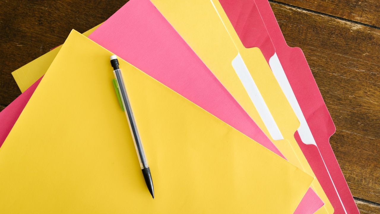 Carpetas de colores con un lápiz encima