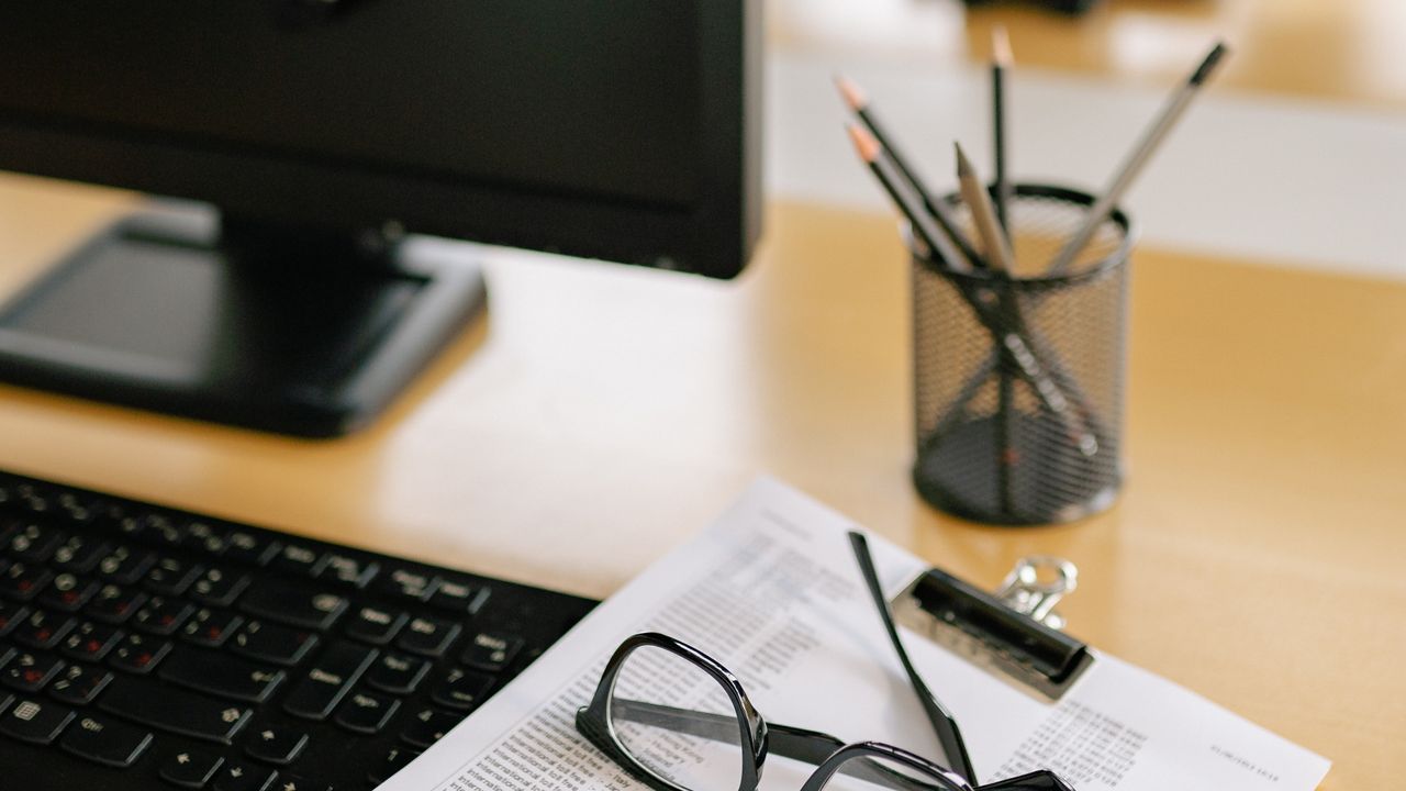 Escritorio de trabajo con computador y lápices