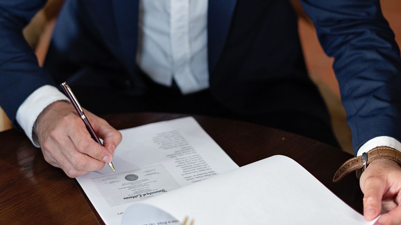 Firma de un documento con lápiz azul