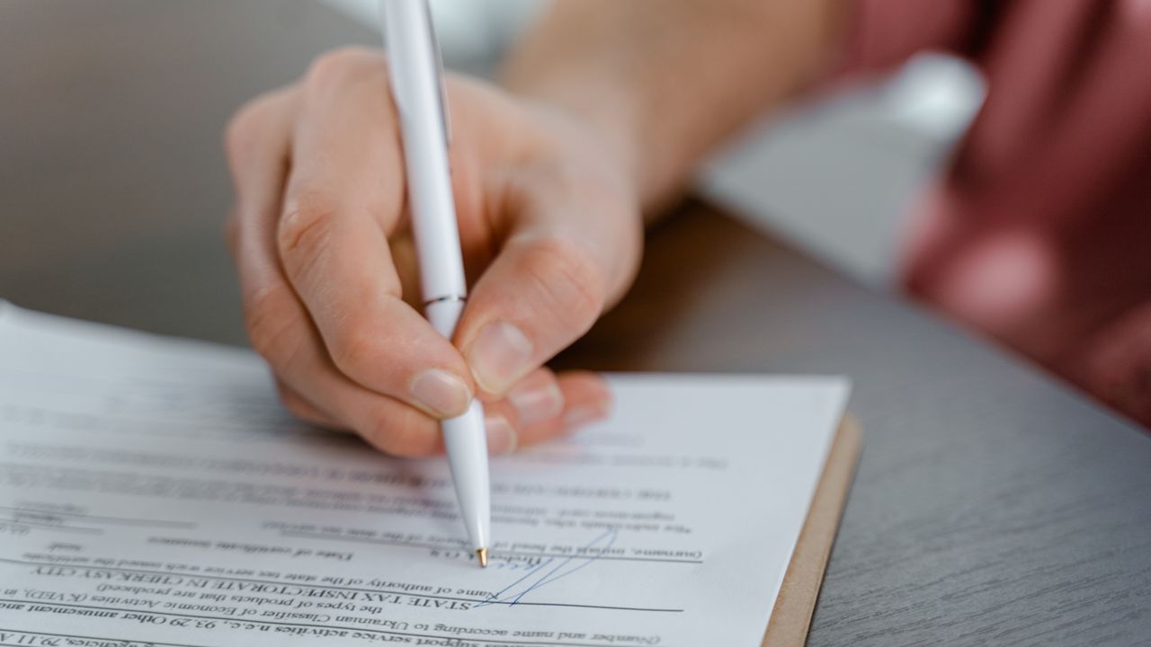 Primer plano de una mano firmando