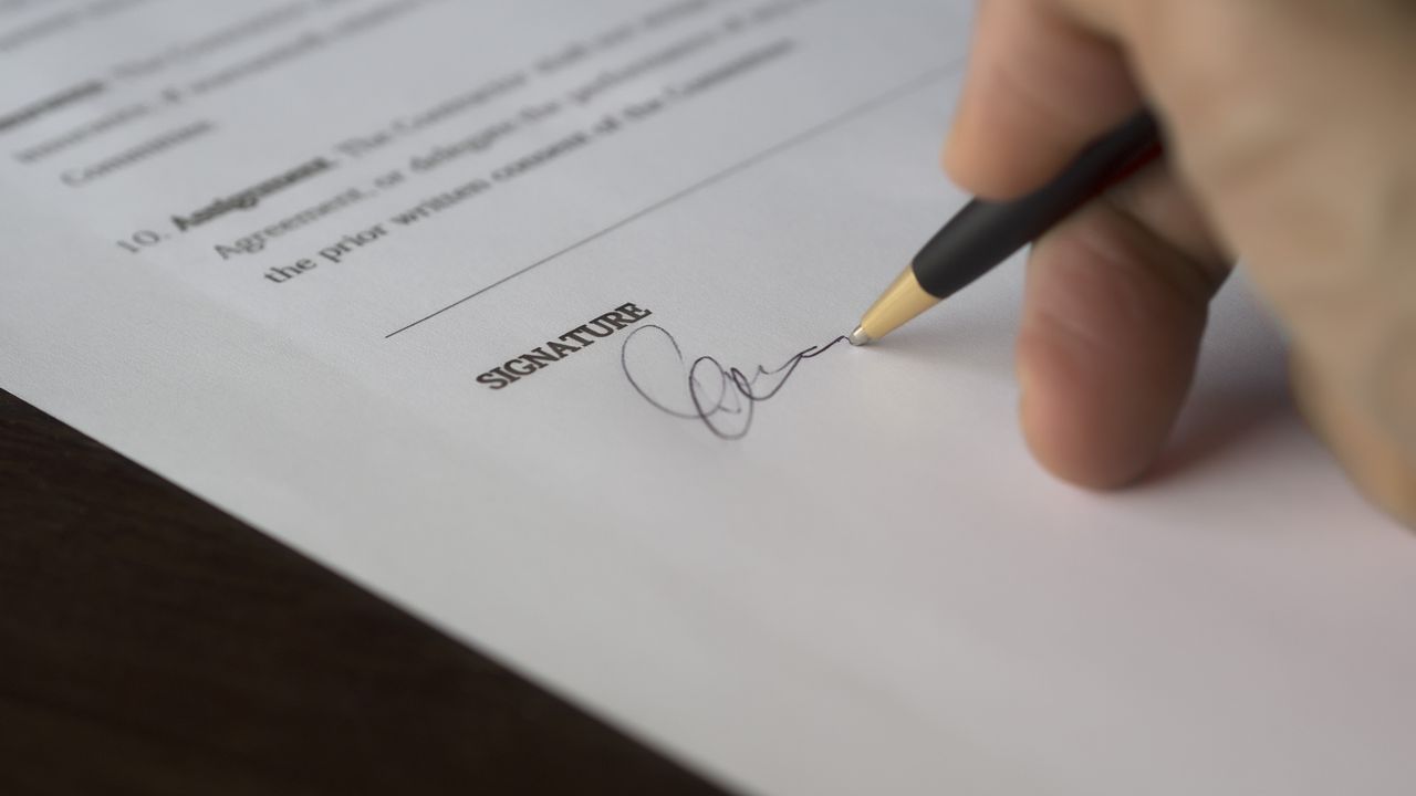 Pluma firmando un documento